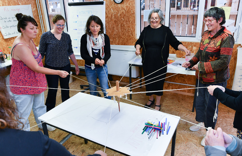 Groupe de personnes autour d'une table jouant au crayon coopératif