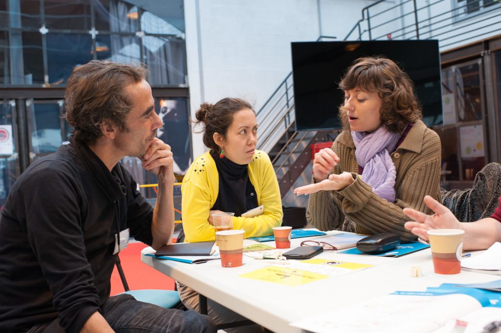 3 personnes discutent autour d'une table